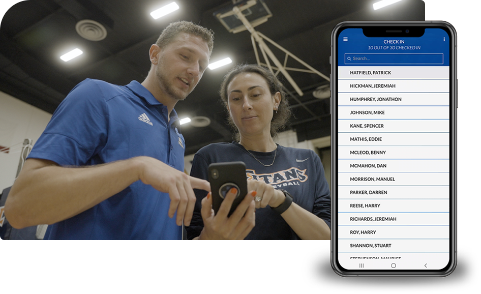 Photo of a coach talking to a female athlete while both are looking at a phone. A mobile device with a screenshot from the Ryzer Go app sits beside it.